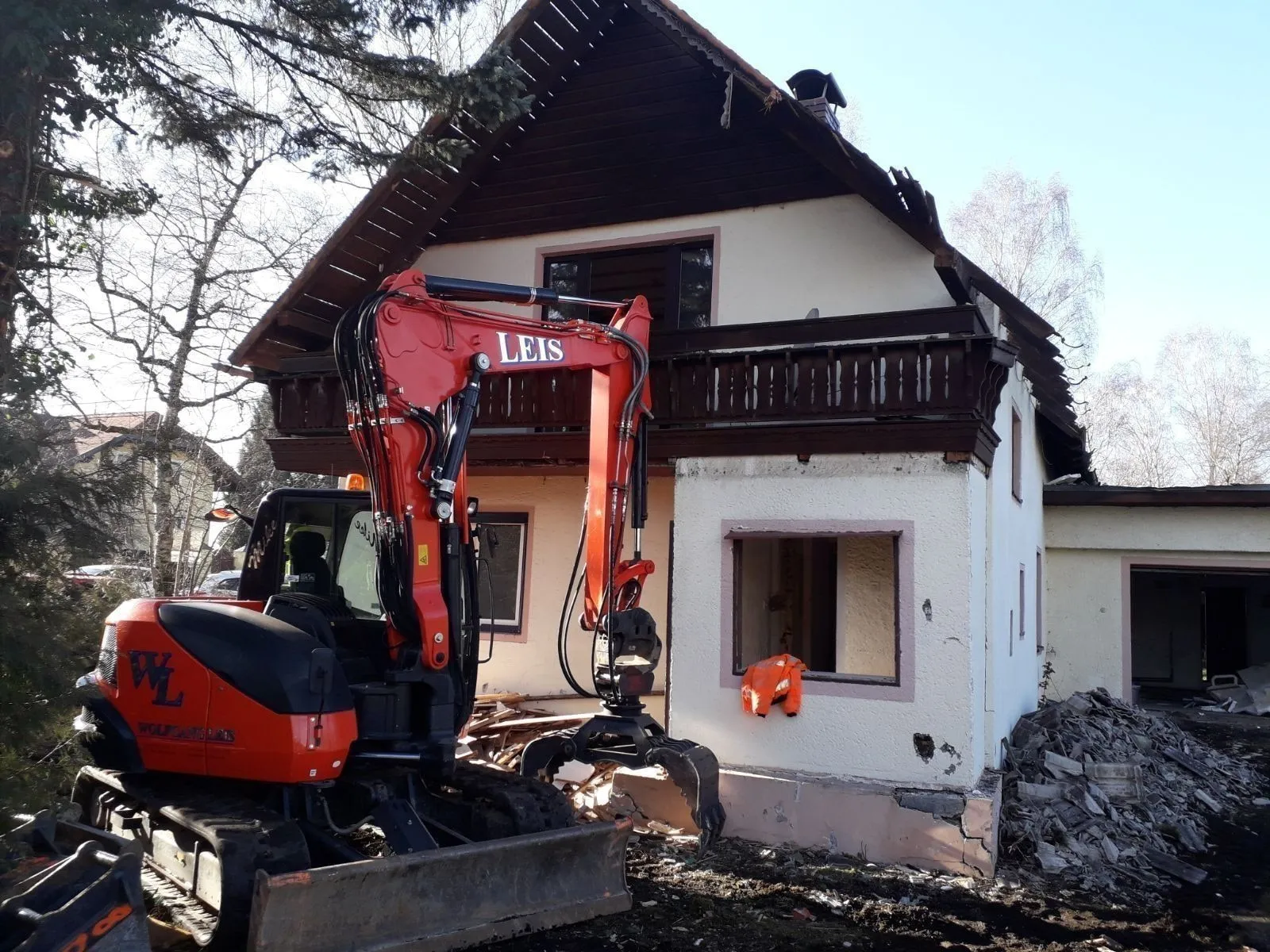 Bagger mit Abbruchgreifer beim Rückbau eines Wohnhauses