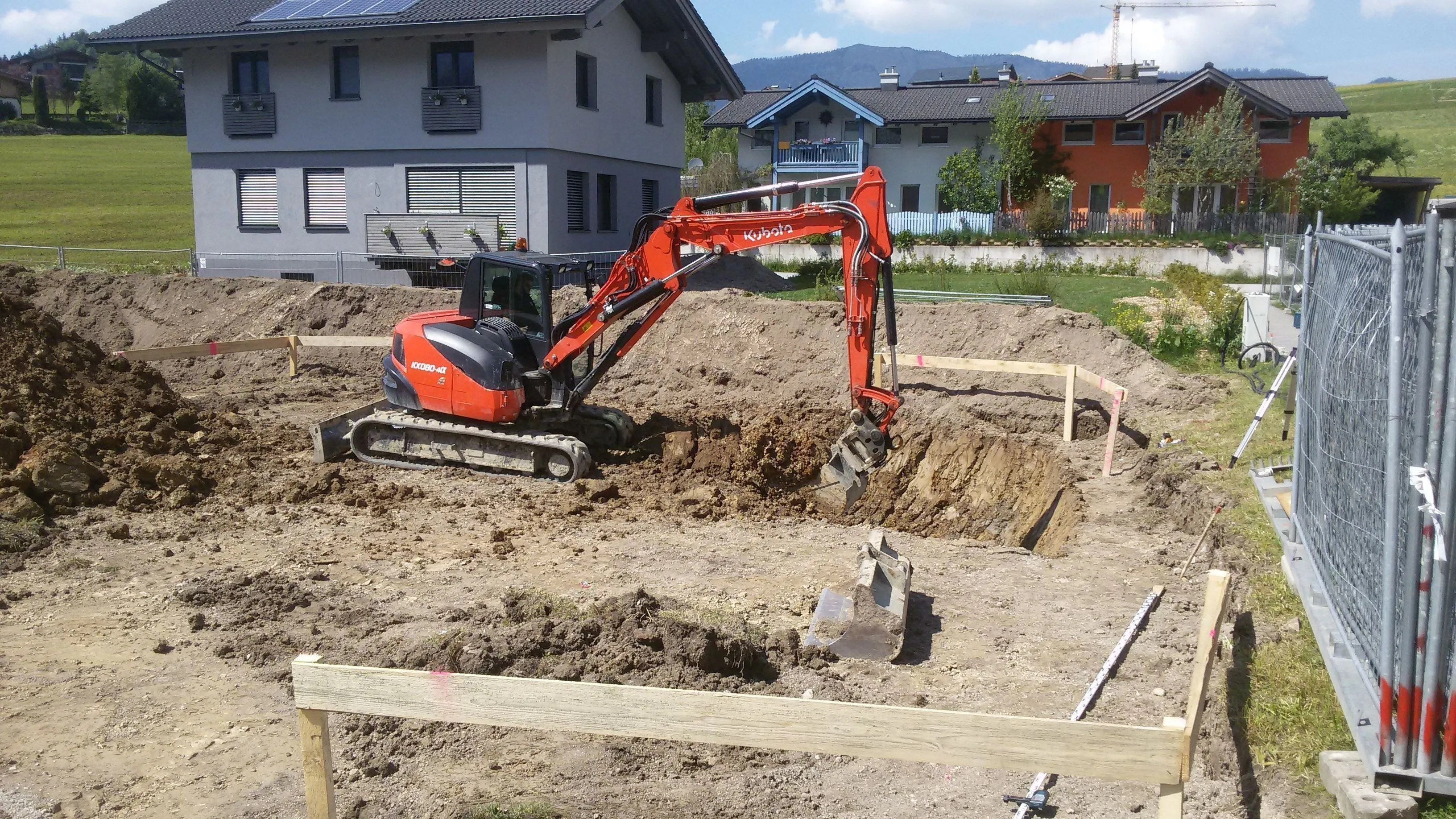 Kubota-Bagger beim Fundamentaushub, rundum das Schnurgerüst
