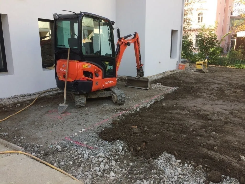 Minibagger bei Außenanlagen-Arbeiten an einem Neubau