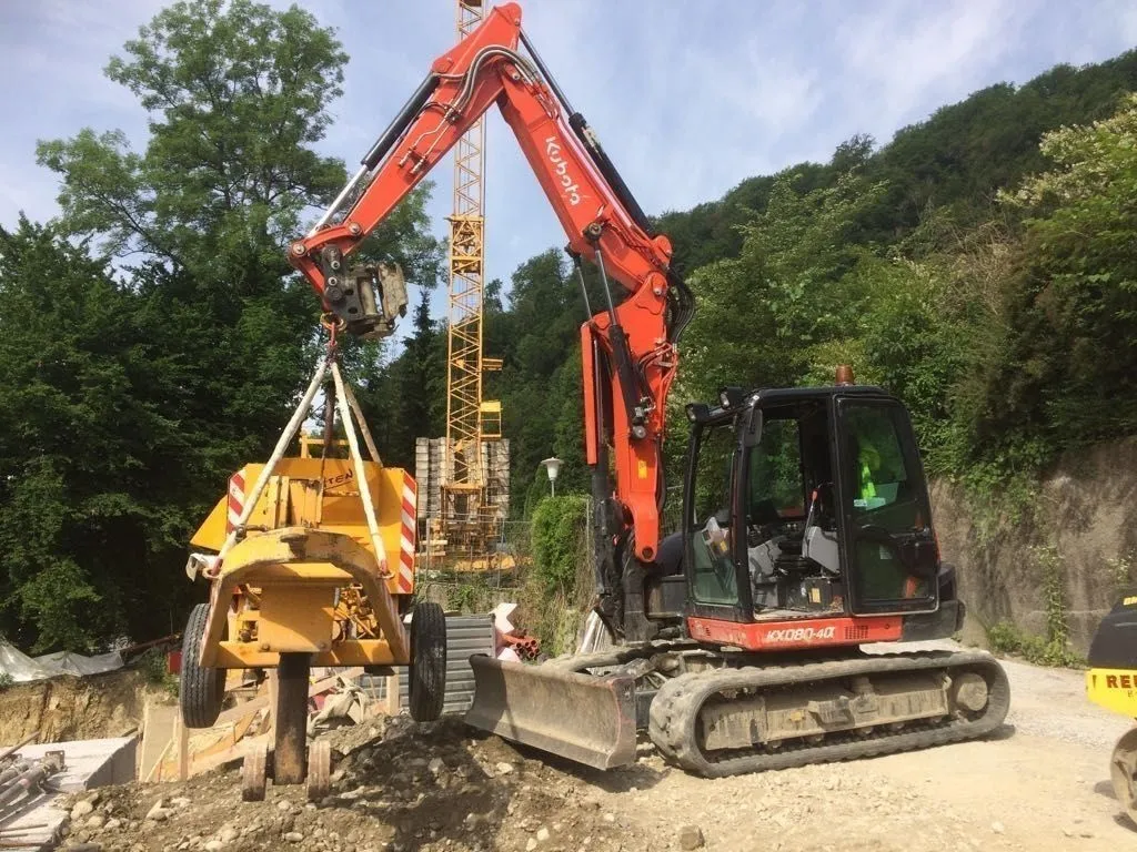 Kubota-Bagger hebt mit Hebegeschirr ein fahrbares Baugerät an