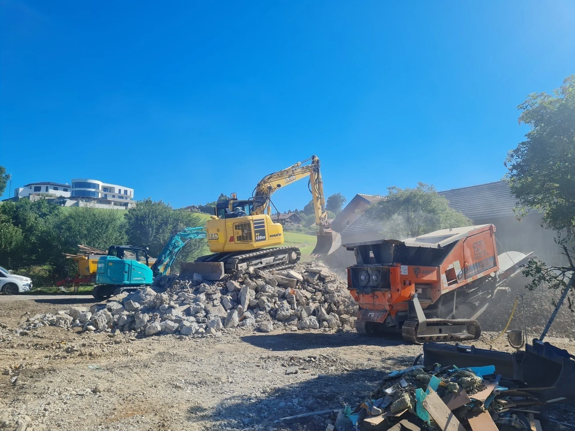 Komatsu-Bagger beschickt einen mobilen Brecher mit Bauschutt