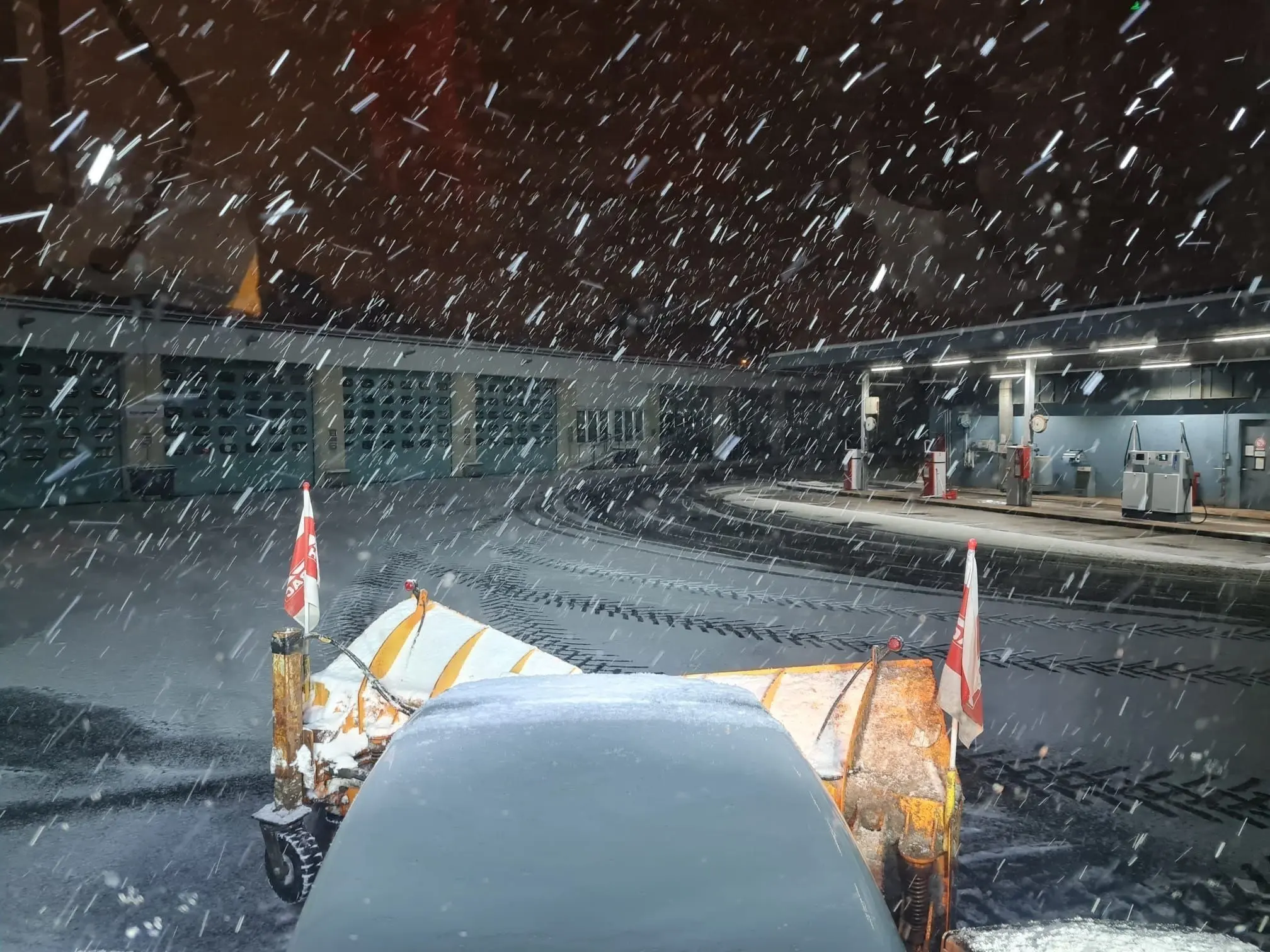 Blick aus der Fahrerkabine über das Schneeschild bei starkem Schneefall